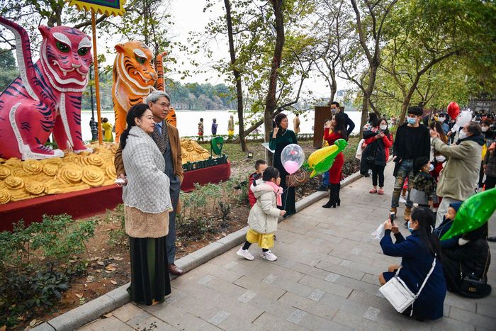 Hình mẫu con hổ trong tranh dân gian Hàng Trống được dựng quanh hồ thu hút nhiều sự chú ý của người dân. Nhiều người dừng lại và chụp bức ảnh kỷ niệm cùng công trình độc đáo này.