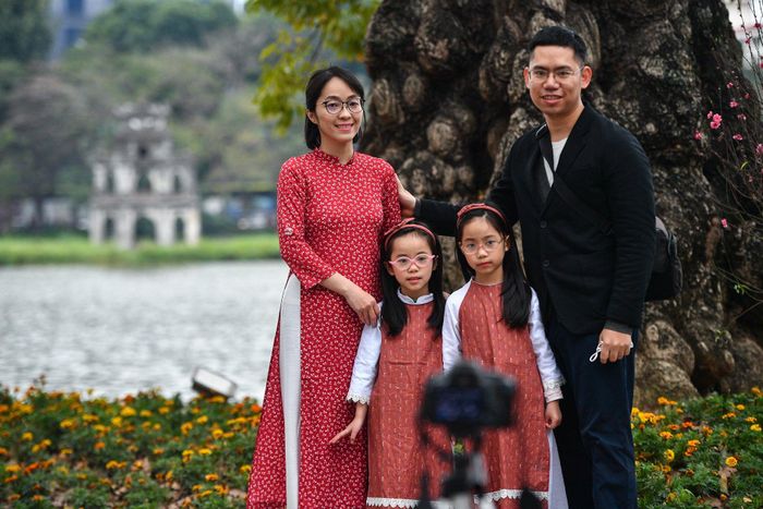 Anh Phúc (quận Hai Bà Trưng) dựng máy ghi lại khoảnh khắc cùng vợ và hai con gái trong ngày đầu năm mới. "Năm nào vợ chồng tôi cũng cho các cháu lên hồ chơi. Năm nay đông hơn so với các năm nên để chụp ảnh cũng khó khăn hơn", anh cho biết.