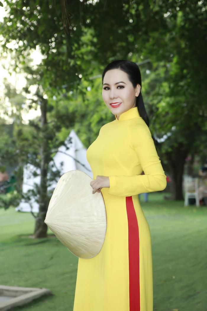 Chiếc áo dài vàng rực rỡ khiến người mặc thêm nổi bật giữa đường xuân