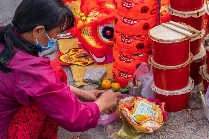 Chợ hoa bến Bình Đông, quầy bán phục trang lân sư rồng hay những món "hàng mã" phục vụ cúng viếng tổ tiên của người dân TP.HCM... được ông Tây thu vào ống kính. Ảnh: JP Klovstad.