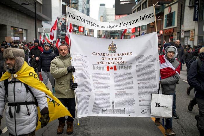  Những người biểu tình mang theo một bản sao của hiến chương về quyền và tự do của Canada, tuần hành trên phố Yonge ở Toronto. 