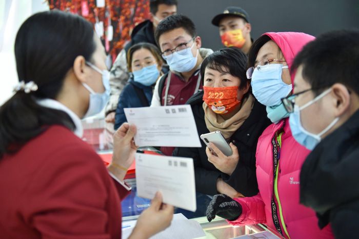  Một nhân viên cửa hàng đang giới thiệu phong bì Olympic cho khách hàng ở Bắc Kinh. Ảnh: Xinhua. 