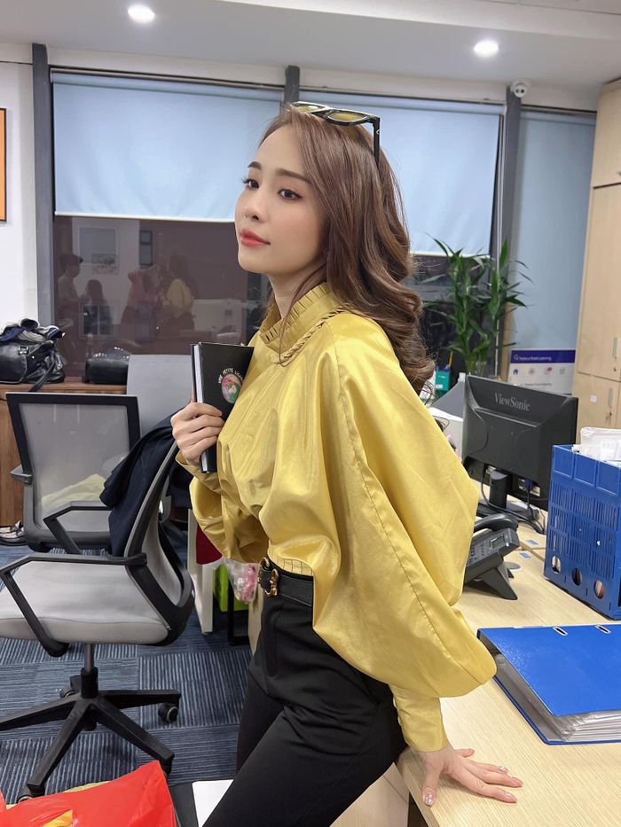 Khi đi làm, Quỳnh Nga lại hiện thân là cô nàng công sở chừng mực với quần âu, áo blouse. Yếu tố vòng eo con kiến luôn được mỹ nhân VTV nhấn nhá quyết liệt.