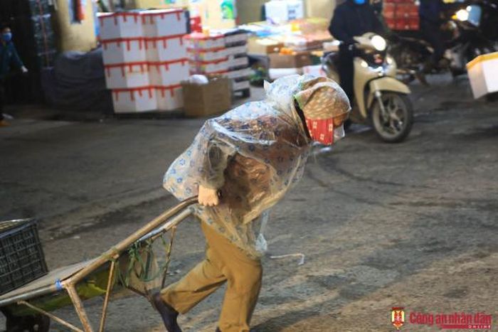 Một cụ già làm nghề khuân vác thuê tại chợ Long Biên rạng sáng 22/2.