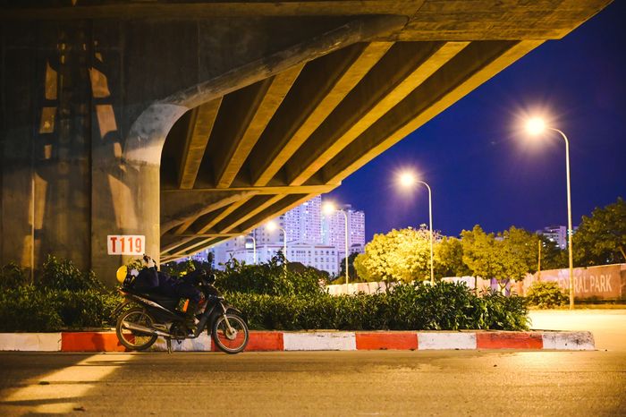  Một tài xế xe công nghệ ngả lưng ở ven đường Nguyễn Xiển (quận Thanh Xuân), chờ những đơn hàng tiếp theo. 