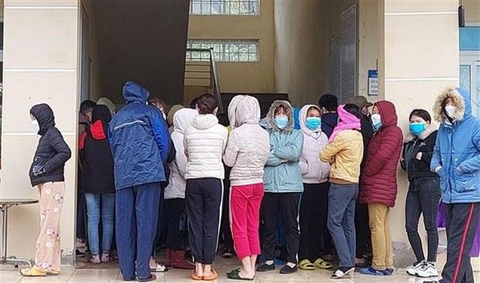 Công nhân chen nhau làm thủ tục xét nghiệm nhanh tại trạm y tế phường Bình Minh, thị xã Nghi Sơn (Thanh Hóa). (Ảnh: Trịnh Duy Hưng/TTXVN)