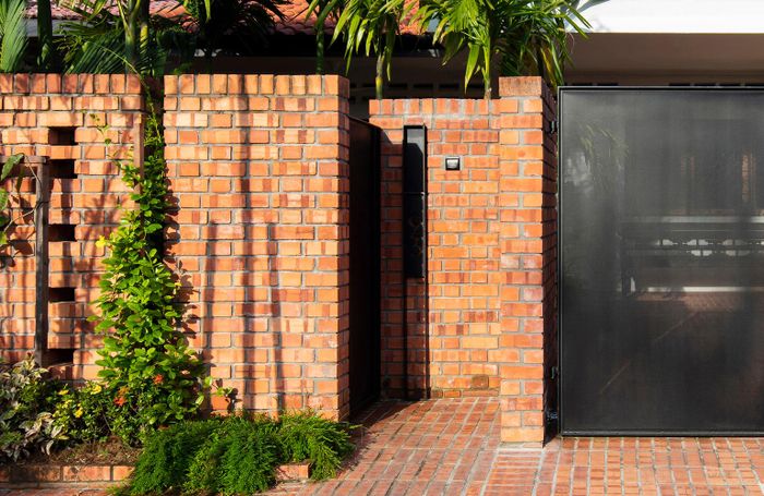 Tường gạch mộc cao lớn và cánh cửa kín đáo, đảm bảo sự riêng tư, cho phép không gian bên trong mở ra bên ngoài. Nguồn ảnh: Archdaily