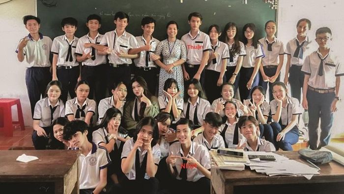 Phú Thuận và Minh Nhựt chụp ảnh kỷ niệm với cô Ngọc Quyên cùng tập thể lớp 10T2.