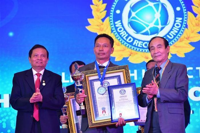 Ông Vũ Đức Đông nhận Bằng công nhận xác lập kỷ lục thế giới “Bộ sưu tập mai vàng Tuệ Sâm có nhiều tác phẩm độc bản nhất”. Ảnh: Nhựt An - TTXVN