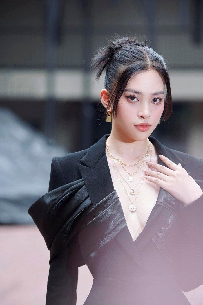 Không những vậy, cô còn nhấn nhá cho phần cổ áo chữ V với chuỗi vòng sợi mảnh màu vàng gold. Cô mix &amp; match với bông tai hình ổ khóa cá tính. Người đẹp chọn cách bới cao tóc tạo nét nghiêm nghị cho gương mặt với vị trí BGK, đồng thời giảm thiểu sự nặng nề cho set đồ màu đen.