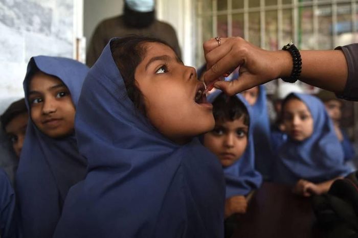 Nhân viên y tế cho bé gái uống vaccine bại liệt tại một trường học ở Karachi, Pakistan. (Nguồn: AFP)