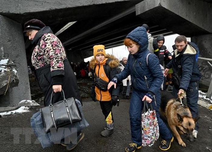 Người dân Ukraine sơ tán khỏi thành phố Irpin, phía Tây Bắc thủ đô Kiev, ngày 8/3. (Ảnh: AFP/TTXVN)