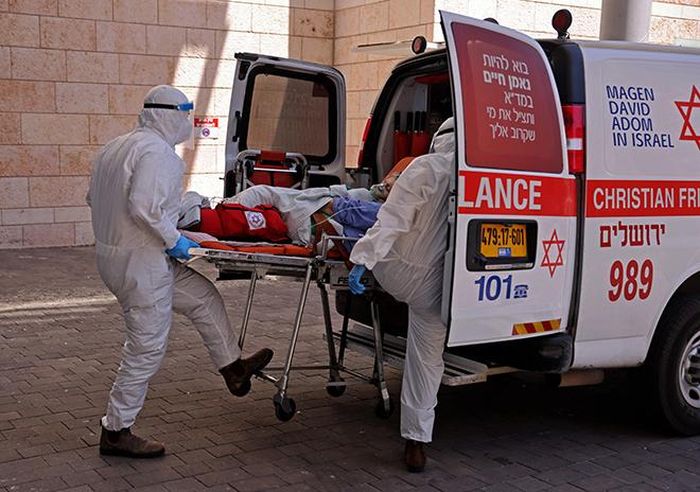 Nhân viên y tế chuyển bệnh nhân COVID-19 tới bệnh viện tại Jerusalem: Ảnh: AFP/ TTXVN