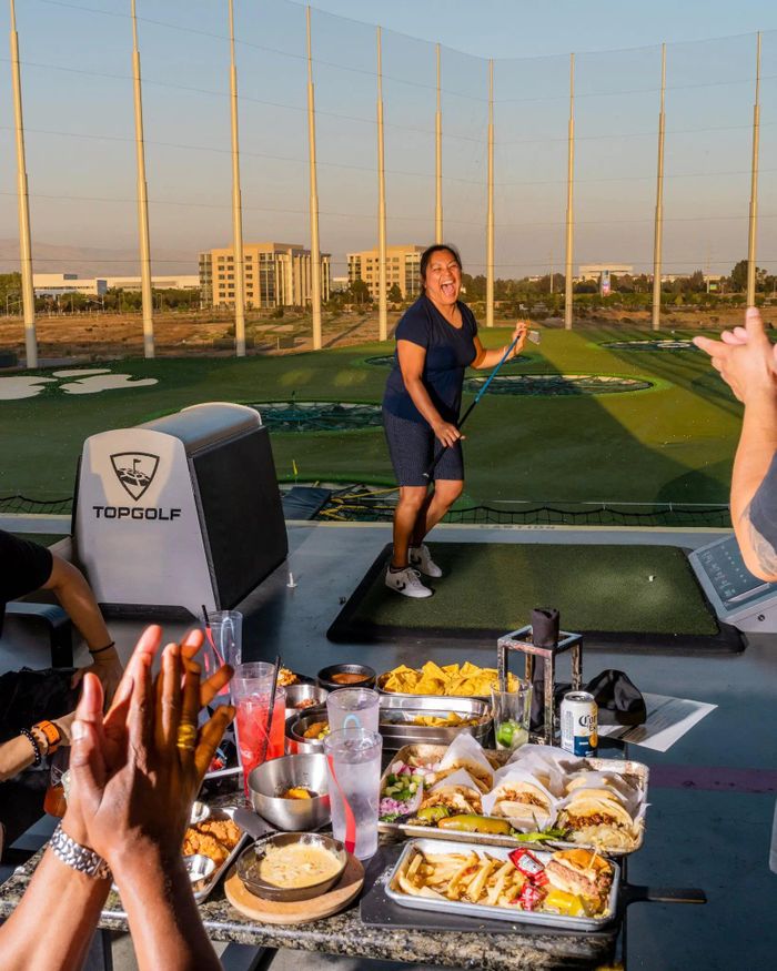  Người chơi vui vẻ ăn uống tại một sân Topgolf tại San Jose, California. Ảnh: Kelsey McClellan/The New York Times. 