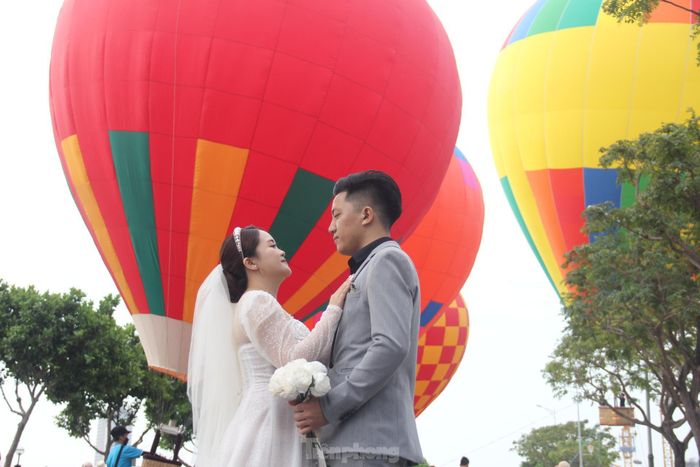 Một cặp đôi chụp ảnh cưới với khinh khí cầu. 
