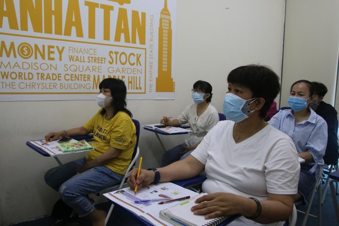 Bà Hà Thị Thủy, 58 tuổi, học viên của lớp học SE1002 (phải) trong giờ học.