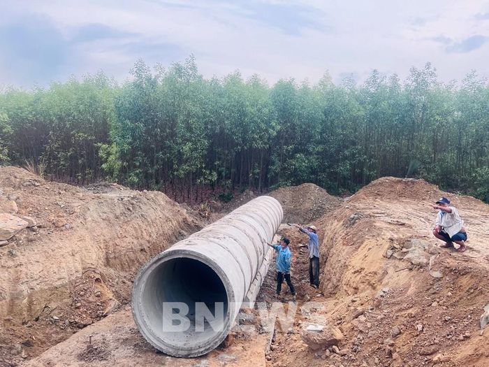 Các công nhân đang hoàn thiện thi công cống thoát nước. Ảnh: Quang Toàn/BNEWS/TTXVN