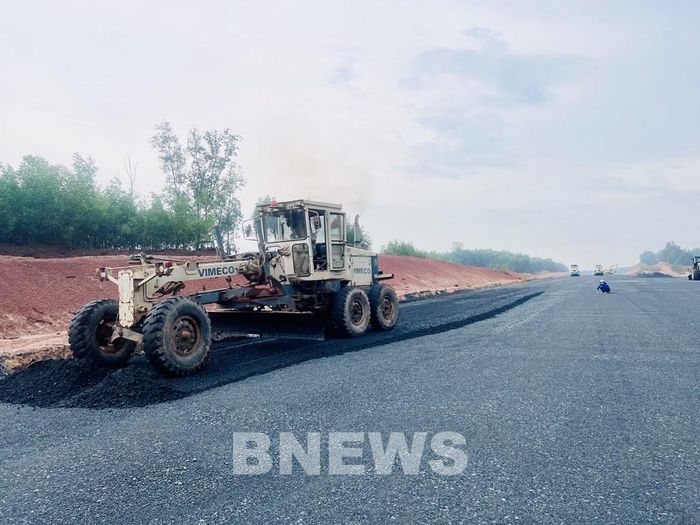 Máy san của nhà thầu đang loại bỏ vật liệu vào lề. Ảnh: Quang Toàn/BNEWS/TTXVN