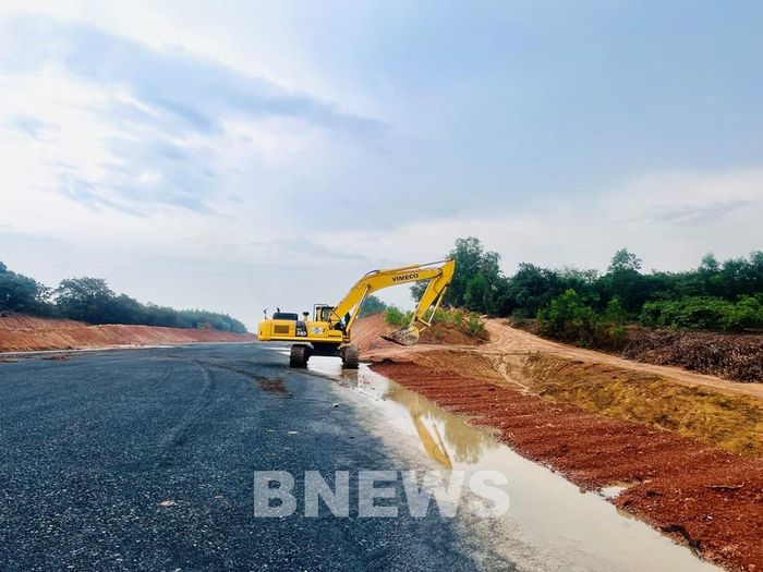 Máy san của nhà thầu đang loại bỏ vật liệu vào lề. Ảnh: Quang Toàn/BNEWS/TTXVN