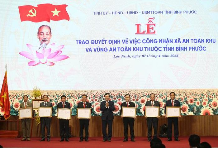 Phó Thủ tướng Phạm Bình Minh trao quyết định công nhận 6 xã, thị trấn là xã An toàn khu và huyện Lộc Ninh là vùng An toàn khu thời kỳ kháng chiến chống Mỹ - Ảnh: VGP/Hải Minh