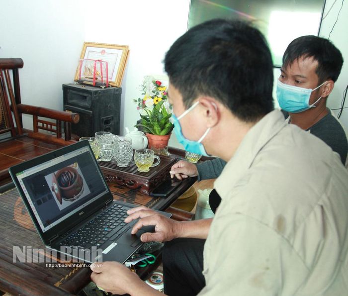 Ông Mai Quang Kìn, Chủ tịch HĐQT Hợp tác xã sản xuất, tiêu thụ cây, con đặc sản an toàn Yên Hòa trao đổi với thành viên Ban quản trị về hình thức bán hàng online.