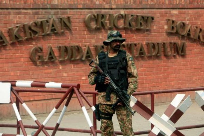 Một người lính Pakistan canh gác trước cổng sân vận động cricket.