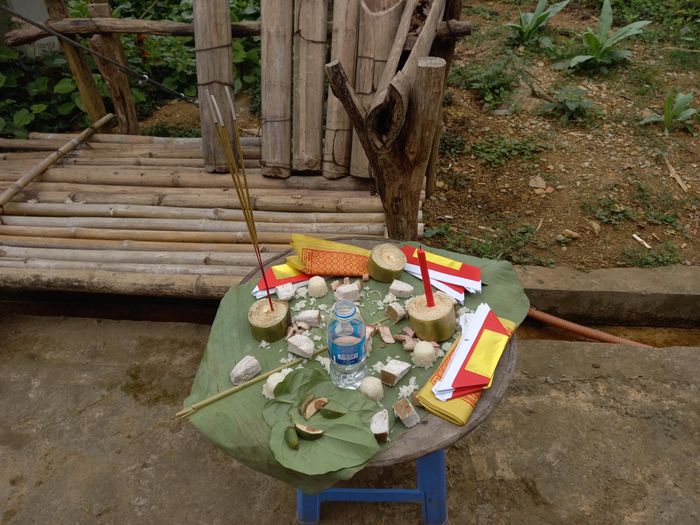 Mâm lễ cúng chúng sinh được đặt ngoài sân trong khi thầy cúng đang làm lễ.