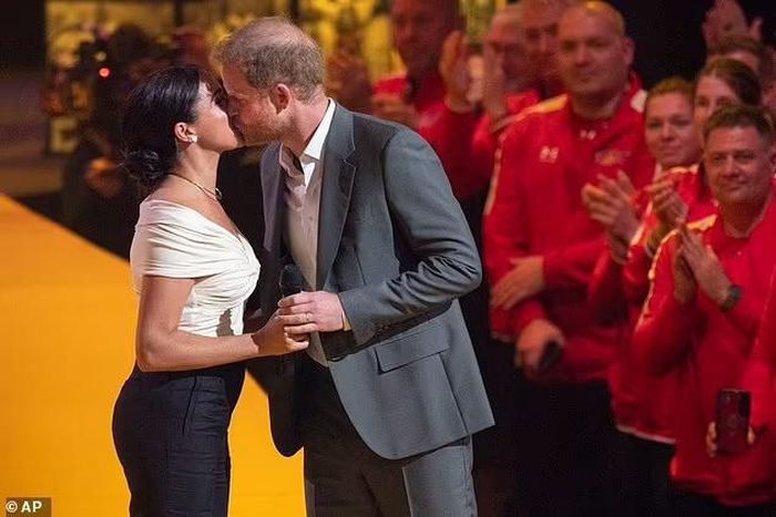  Harry được cổ vũ khi hôn vợ trên sân khấu lớn. Ảnh: AP. 