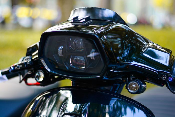  Một chiếc Vespa Sprint được chủ xe nâng cấp hệ thống chiếu sáng với chóa đèn chính gồm 4 LED gương cầu, hai bên có thêm cặp đèn LED trợ sáng. 
