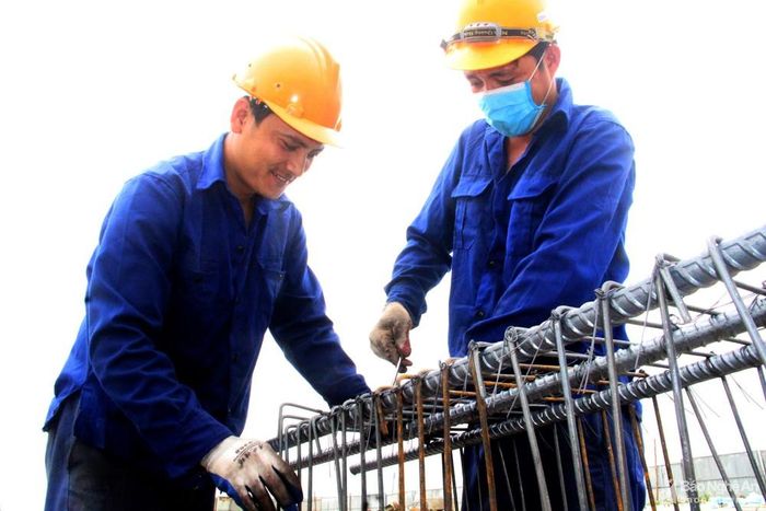 Các công nhân thi công cầu vượt tại điểm giao cắt giữa cao tốc Bắc - Nam và đường N2. Ảnh: Q.A