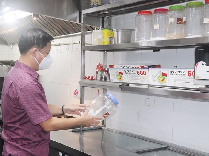 Ông Đặng Thanh Phong - Chi cục trưởng Chi cục ATVSTP Hà Nội kiểm tra việc niêm yết tem, nhãn trên các gia vị, thực phẩm tại bếp ăn của nhà hàng Isushi.