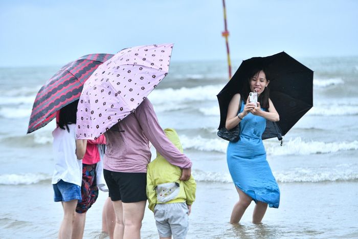 Chị Vân cùng gia đình từ Hà Nội tới Sầm Sơn du lịch, chia sẻ: "Mưa nhưng bọn trẻ nhà tôi vẫn muốn ra biển, tôi cũng phải đi để theo sát các con. Mưa gió lớn nên chúng tôi chỉ chơi ở gần bờ, không xuống tắm vì sợ nguy hiểm".