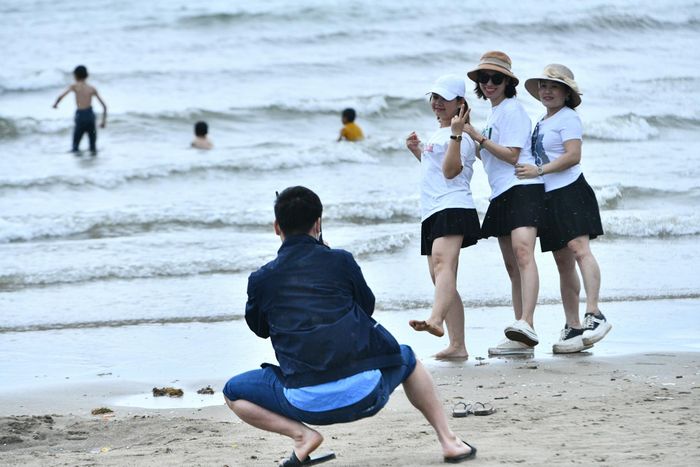 Dù mưa gió, khách du lịch vẫn tranh thủ chụp ảnh làm kỷ niệm trước khi kết thúc kỳ nghỉ.
