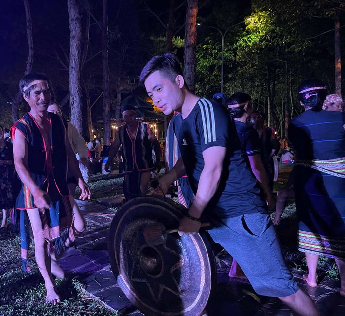 Nghệ nhân huyện Đak Đoa hướng dẫn du khách tư thế đánh cồng chiêng.