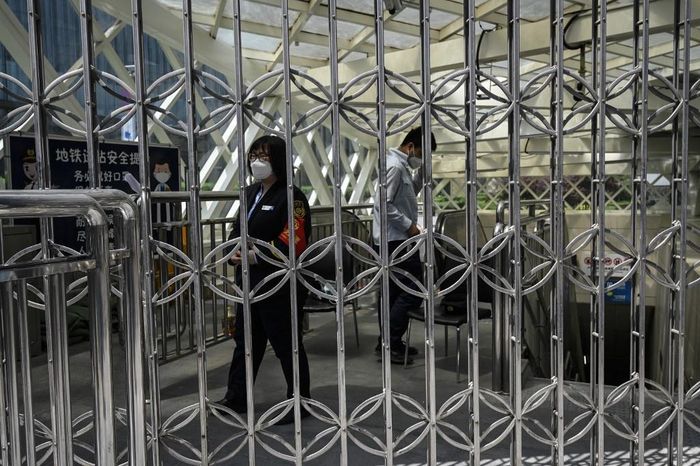  Nhân viên đứng trước lối xuống ga tàu điện ngầm đã bị đóng cửa. Ảnh: AFP. 