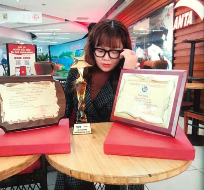 Nhà báo dỏm Nguyễn Thị Vân Anh bên các giấy tờ, huy hiệu làm giả để tạo hình ảnh lừa đảo các bị hại