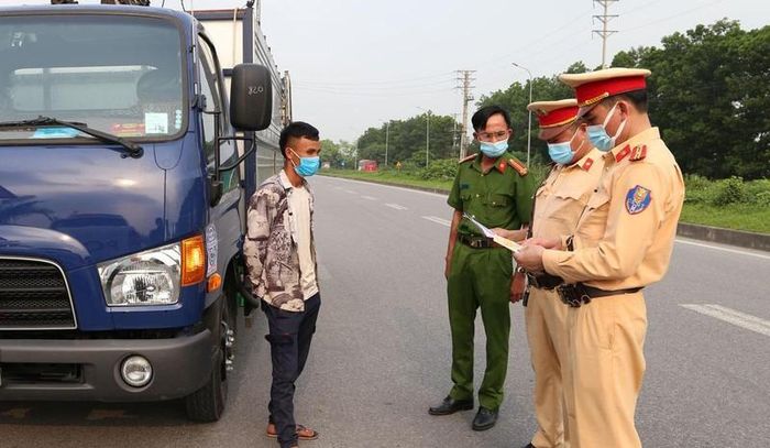 Lực lượng chức năng kiểm tra xe tải vi phạm.