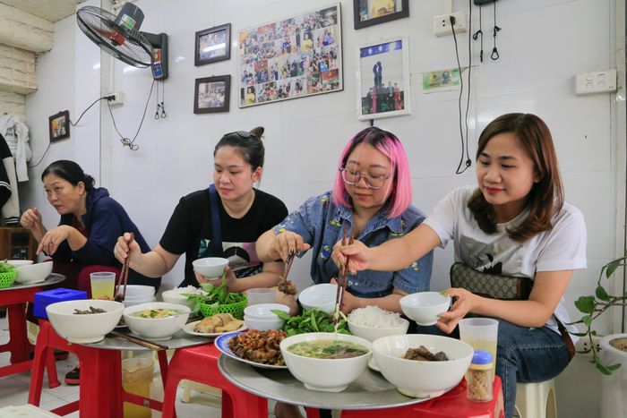  Chị Diệp (tóc hồng) đi cùng với nhóm bạn từ Khâm Thiên (quận Đống Đa) lên Hàng Lược (quận Hoàn Kiếm) để thưởng thức món ăn yêu thích của mình. "Tôi và các bạn đều là tín đồ của món ngan cháy tỏi. Đây là quán quen của mọi người. Chúng tôi cũng có đi ăn thêm vài quán khác nhưng cảm thấy không hợp khẩu vị của mình", chị nói. 