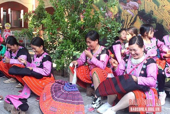 Đồng bào dân tộc Mông bản Tà Số 2, xã Chiềng Hắc, huyện Mộc Châu trình diễn thêu hoa văn trên vải. 