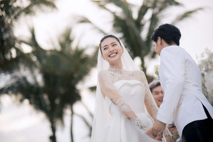 Vợ chồng Ngô Thanh Vân cười rạng rỡ khi nắm tay hạnh phúc trên sân khấu chính.