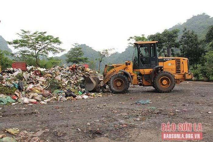 Máy xúc vận chuyển rác đi phân loại. 