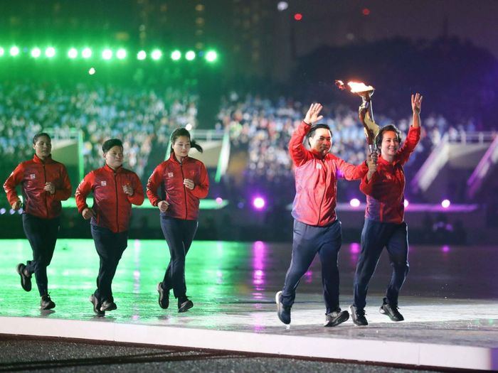 Bộ đôi cựu VĐV Hoàng Anh Tuấn (Cử tạ), Nguyễn Thúy Hiền (Wushu) rước đuốc trong lễ khai mạc SEA Games 31. Ảnh: TTXVN