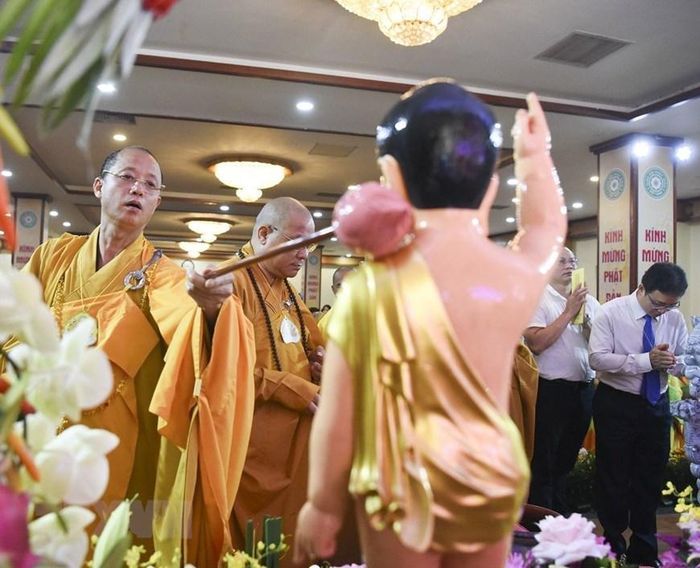  Các chư tôn đức và các vị đại biểu thực hiện nghi lễ tắm Phật truyền thống. (Ảnh: TTXVN) 