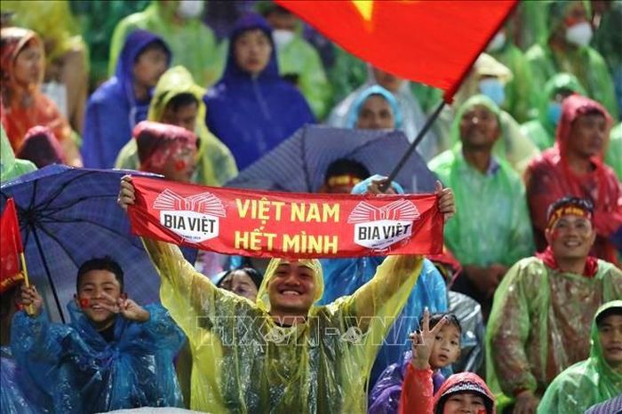 Khán giả đội mưa đến cổ vũ cho đội nhà. Ảnh: TTXVN