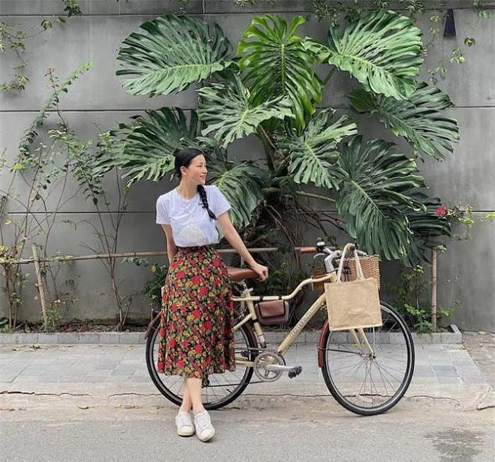 Để cân bằng set đồ, Phương Khánh kết hợp áo thun trắng với chân váy hoa nổi bật. Set đồ trở nên xinh tươi, sành điệu hơn nữa khi nàng hậu đi một đôi sneaker trắng.