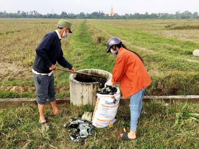 Đoàn viên thanh niên cùng người dân xã Cẩm Vịnh tập kết vỏ bao thuốc bảo vệ thực vật trên đồng ruộng.