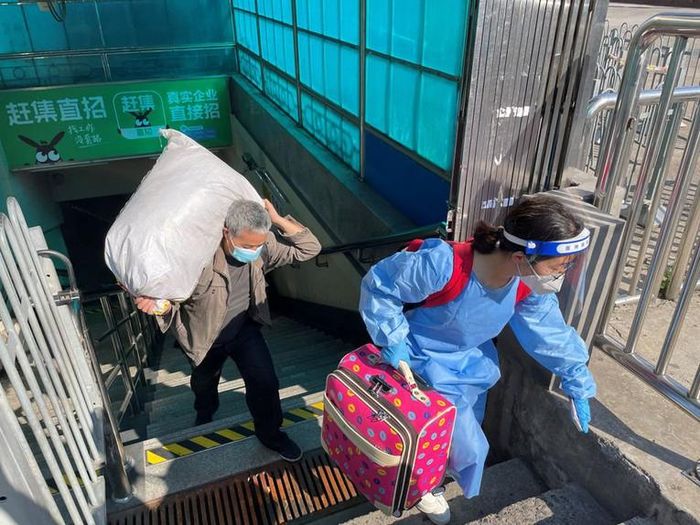 Du khách mang theo hành lý rời ga tàu điện ngầm ở Thượng Hải, Trung Quốc, ngày 22/5. Ảnh: Reuters