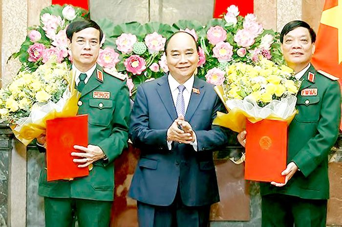 Chủ tịch nước Nguyễn Xuân Phúc, Thống lĩnh các lực lượng vũ trang nhân dân, Chủ tịch Hội đồng Quốc phòng và An ninh, trao Quyết định thăng quân hàm từ Trung tướng lên Thượng tướng đối với đồng chí Ngô Minh Tiến và Lương Đình Hồng. Ảnh: TTXVN