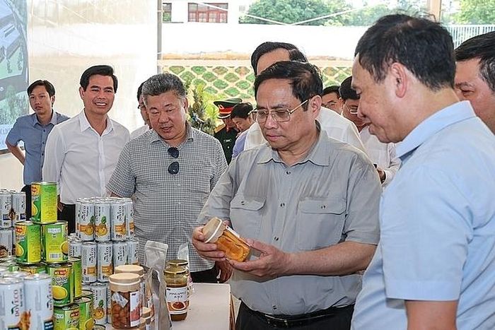 Thủ tướng nghe giới thiệu về một số sản phẩm đóng hộp xuất khẩu của Trung tâm Chế biến rau quả Doveco Sơn La - Ảnh: VGP/Nhật Bắc