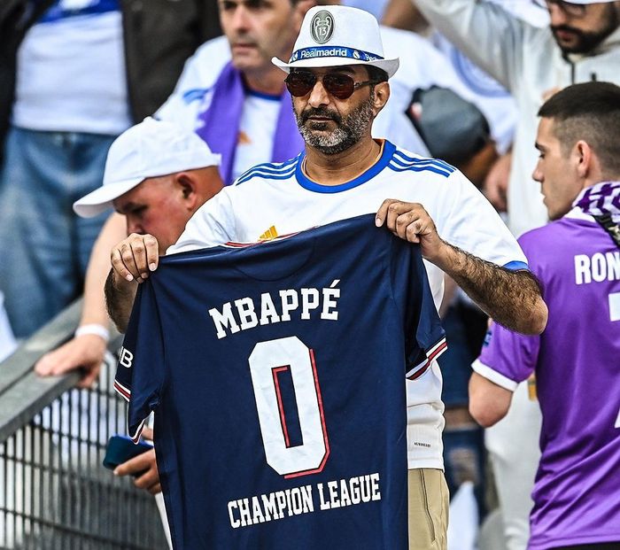 Tại Stade de France, nơi diễn ra trận chung kết Champions League 2021/22, CĐV Real Madrid mang theo áo đấu Kylian Mbappe vào sân và chế giễu tiền đạo người Pháp. Họ giơ cao chiếc áo in tên Mbappe cùng số lần vô địch Champions League của cầu thủ này (0 danh hiệu).
